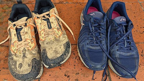 Two pairs of trainers, one muddy