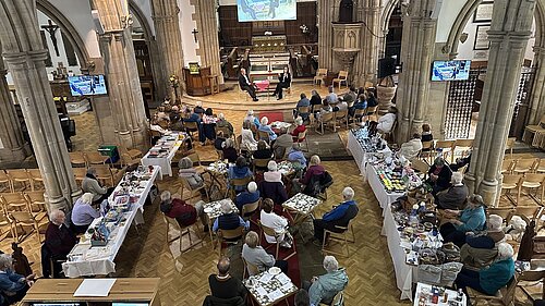 Holy Trinity Church Hurstpierpoint with people around tables and a Q&A session ongoing